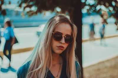 Portrait of young woman wearing sunglasses in city