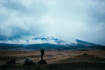 Man standing on snowcapped mountain against sky