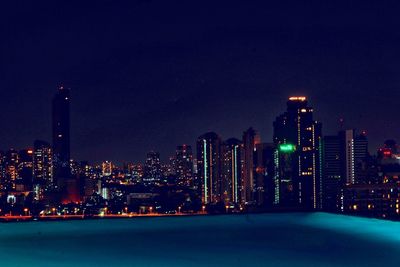 Illuminated buildings against sky at night