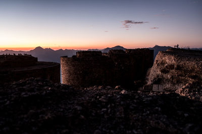 Silhouette buildings against sky during sunset