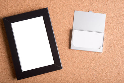 Low angle view of picture frame and paper on table