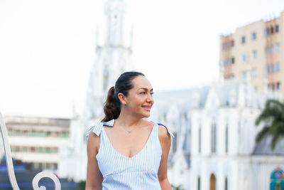 Beautiful tourist woman at the ortiz bridge with la ermita church on background in the city of cali