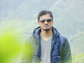 Portrait of young man wearing sunglasses standing outdoors