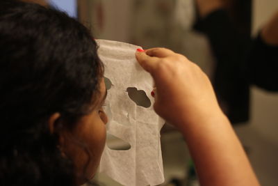 Woman using facial mask at home