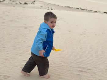 Cute boy with toy on beach