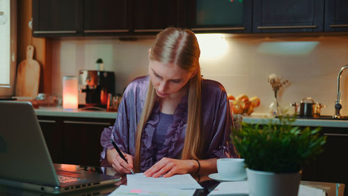 Young woman using mobile phone at home