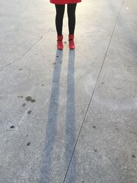 Low section of woman standing on road