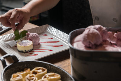 Hand holding ice cream on table