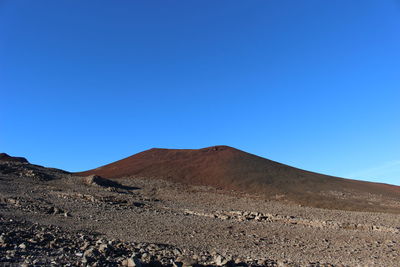 Scenic view of desert against clear blue sky