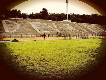 Man playing soccer field against sky