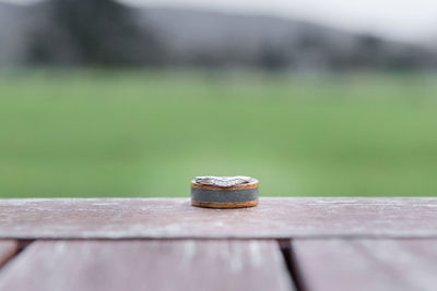 Close-up of wedding ring on wooden table