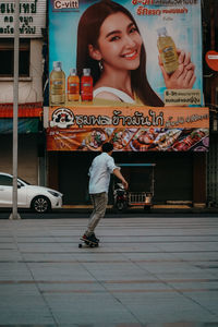 Full length of woman standing on footpath in city