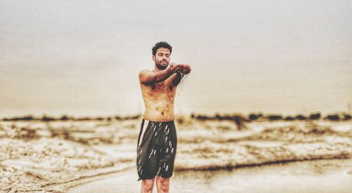 Portrait of young man standing on beach