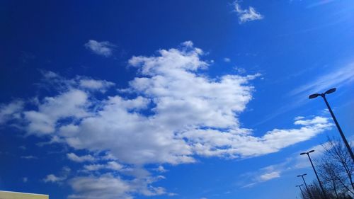 Low angle view of power lines against blue sky