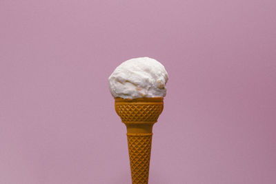 Ice cream cone against pink background colored  ice cream cone on a sunny day