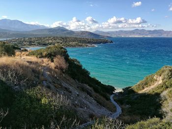 Scenic view of sea and mountains against sky