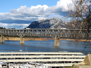 Bridge over river against mountains and sky