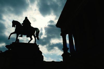 Low angle view of silhouette statue against sky