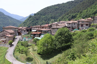 Houses by trees and mountains against sky