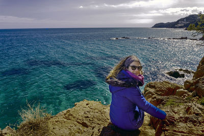 Woman standing in sea against sky