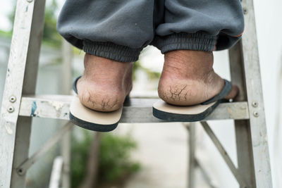 Low section of man standing on railing