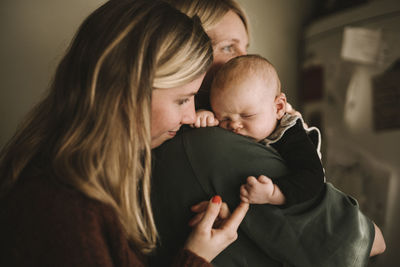 Mothers holding sleeping newborn baby