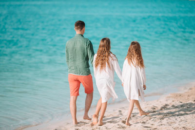 Rear view of friends standing on beach