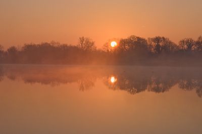 Scenic view of lake against orange sky