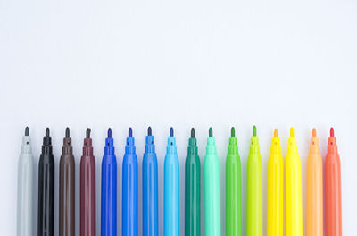 Close-up of colored markers against white background