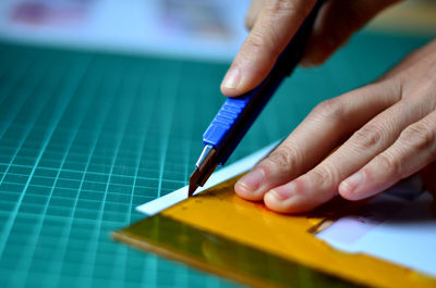 Close-up of cropped hands cutting paper