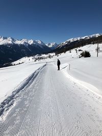 Man standing on snowy road against clear sky