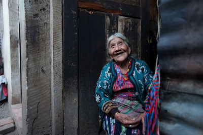 Portrait of woman standing against wall