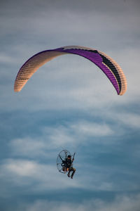 Low angle view of person paragliding against sky