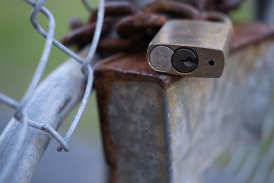 Close-up of rusty metal fence against blurred background