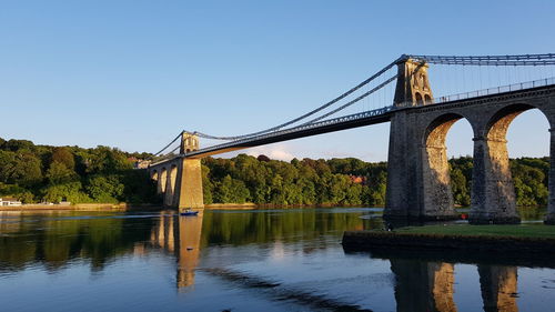 Arch bridge over river against sky