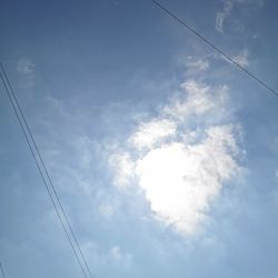 Low angle view of power cables against sky