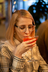 Young woman drinking margarita cocktail in a restaurant