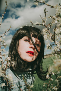 Portrait of woman with flowers against blurred background