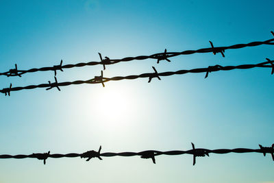 Low angle view of barbed wire against clear sky