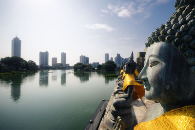Rear view of woman sitting by lake