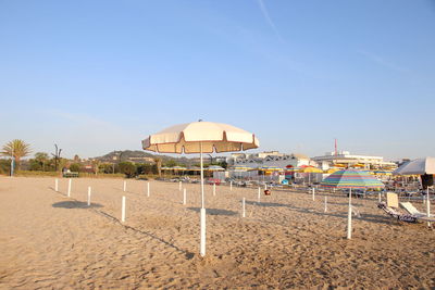 Lifeguard hut on beach against clear blue sky