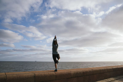 Young woman practicing yoga near the sea