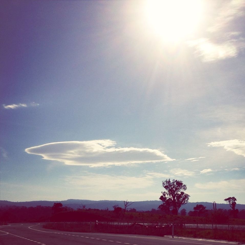 sky, cloud - sky, landscape, blue, scenics, tranquil scene, tranquility, beauty in nature, cloud, sunlight, nature, transportation, sun, sunbeam, outdoors, road, mountain, day, no people, idyllic