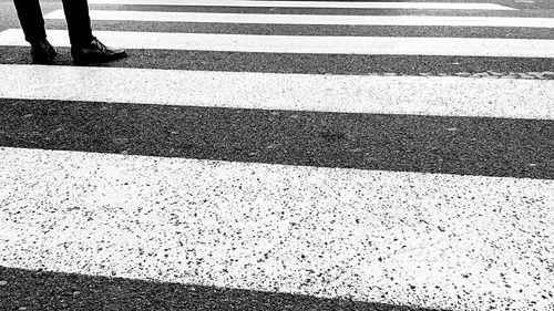 Low section of man walking on road