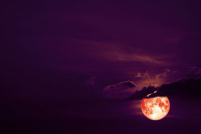 Low angle view of illuminated moon against sky at sunset