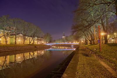 Light trails on street by river at night