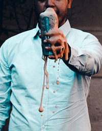 Close-up of man holding exploding drink