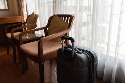 Luggage by empty chairs at home