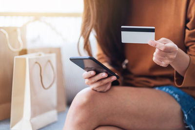 Midsection of woman using mobile phone