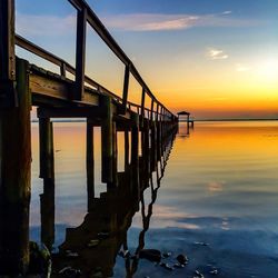 Pier on sea at sunset